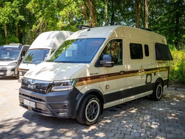 Sven Hedin 50 Jahre Edition – Beiges Sven Hedin Jubiläums-Reisemobil von vorne schräg im Freien.