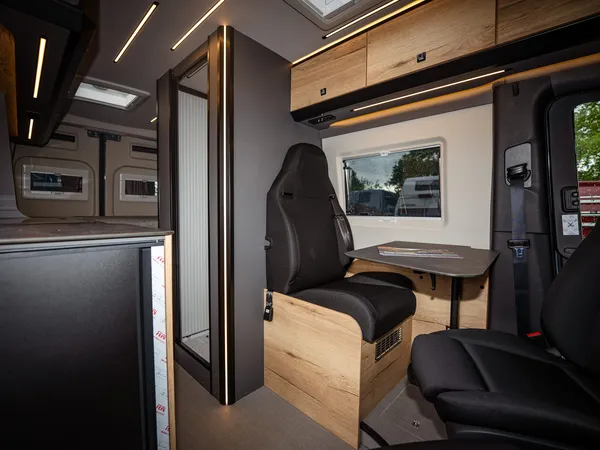 Roadstar XT – Innenansicht des Reisemobils mit Sitzgruppe, Tisch und Blick in den hinteren Bereich.