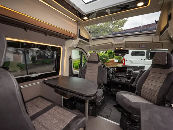 Summit Prime 640 – Gemütliche Sitzgruppe mit drehbaren Cockpitsitzen und Tisch im Reisemobil.
