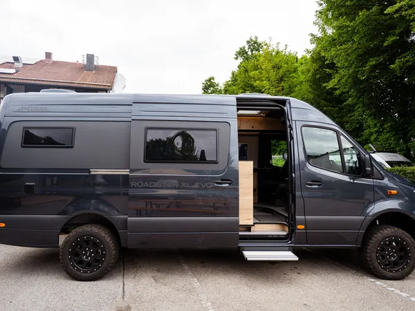 Roadstar XL Evo – Dunkelgrauer Pössl Roadstar XL Evo Kastenwagen mit offener Schiebetür, seitliche Ansicht.
