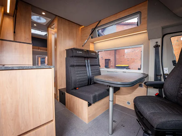 Avanti F – Sitzgruppe mit Tisch und drehbarem Fahrersitz in hellem Holzdesign.