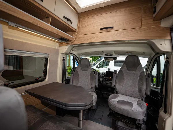 Roadcruiser Revolution – Innenansicht des Wohnmobils mit Sitzgruppe und gedrehten Fahrerhaussitzen.