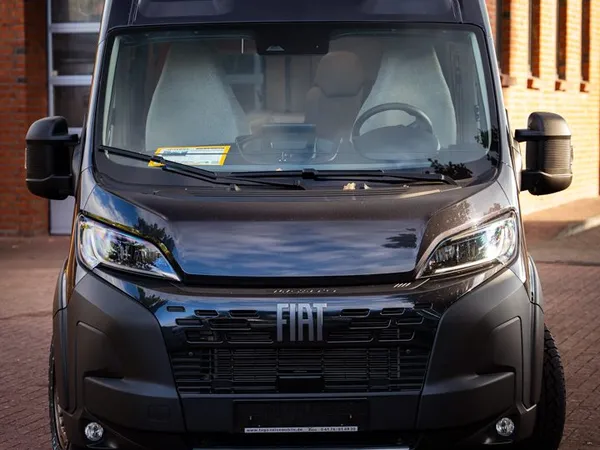 Trenta 640 – Schwarzer Kastenwagen-Reisemobil Trenta 640 von vorne auf gepflastertem Boden.