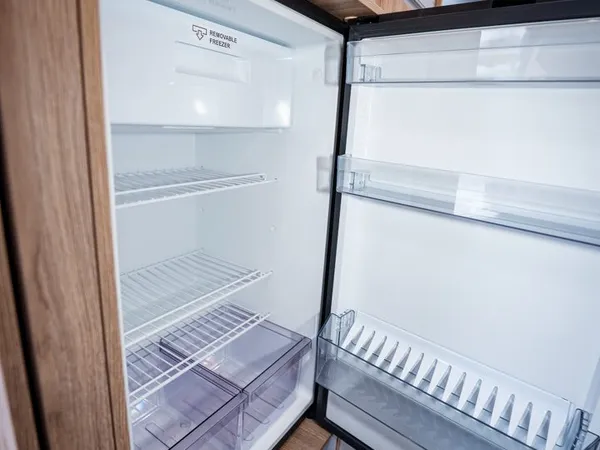 Avanti C – Geöffneter Kühlschrank mit Eisfach und Schubladen im Reisemobil.