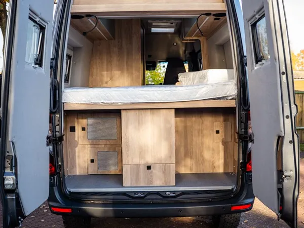 Regent E – Heckansicht des Reisemobils mit geöffneten Türen, zeigt Heckstauraum und Bett.