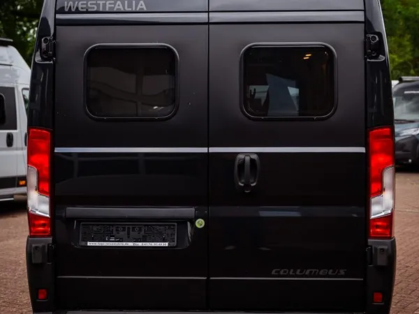 Columbus 600 D – Schwarzes Westfalia Columbus Reisemobil von hinten auf Pflastersteinen