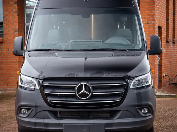 Roadstar X – Frontansicht eines schwarzen Roadstar X Reisemobils vor einem Backsteingebäude.