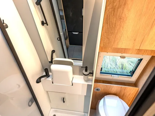 Avanti R – Modernes Reisemobil-Bad mit Dusche, Toilette, Waschbecken und Spiegel.