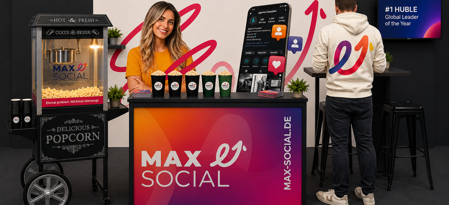 MAXSOCIAL Messestand mit gebrandeter Popcornmaschine, Theke im Farbverlauf und Smartphone-Mockup des Instagram-Profils