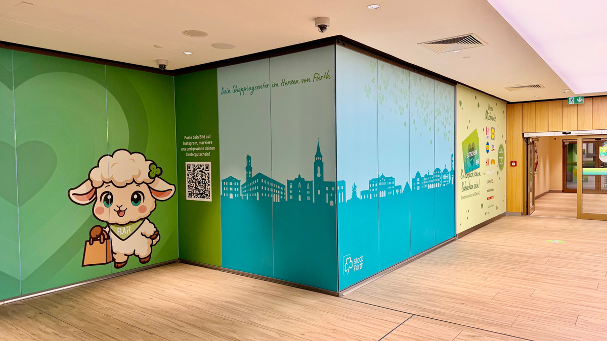 Eckwand-Beklebung im FLAiR Fürth: FLAiRY mit Einkaufstüte, QR-Code zur Instagram-Gewinnaktion und türkisfarbene Silhouette der Fürther Skyline