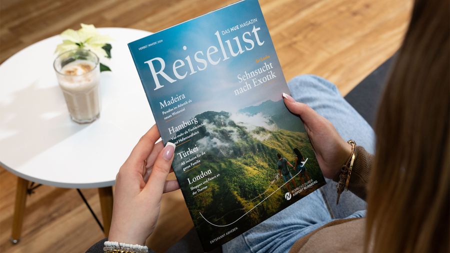 Person blättert im Reiselust-Magazin des Albrecht Dürer Airport Nürnberg