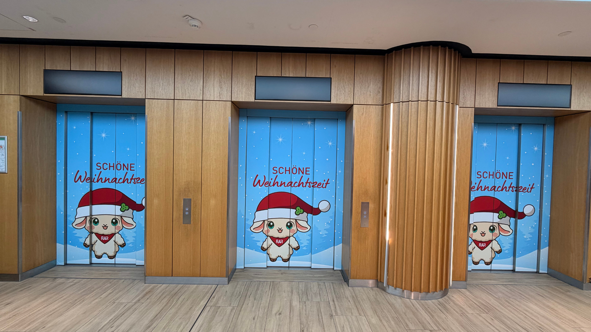 Drei weihnachtlich beklebte Aufzugtüren im FLAiR Fürth: FLAiRY mit Nikolausmütze vor Schneelandschaft und Schriftzug „Schöne Weihnachtszeit“