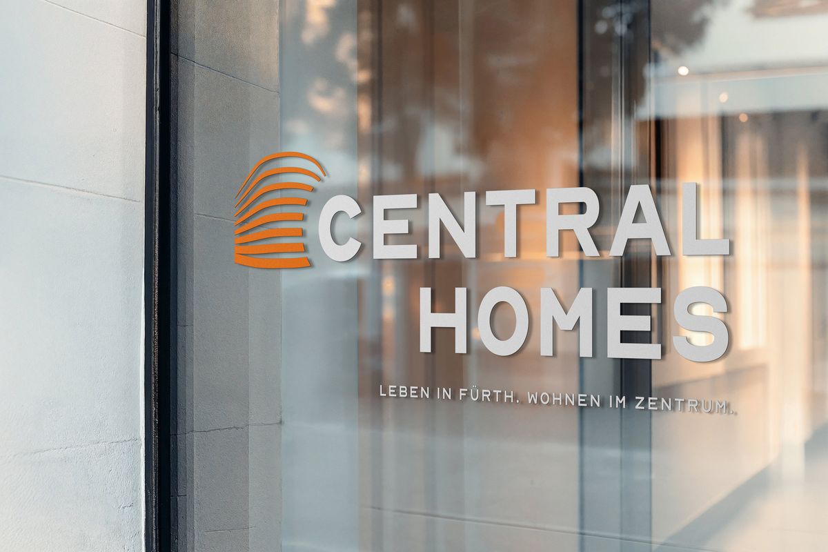Central-Homes-Logo mit orangefarbener Bildmarke und dem Claim „Leben in Fürth. Wohnen im Zentrum.“ als Beschriftung auf einer Glasfassade
