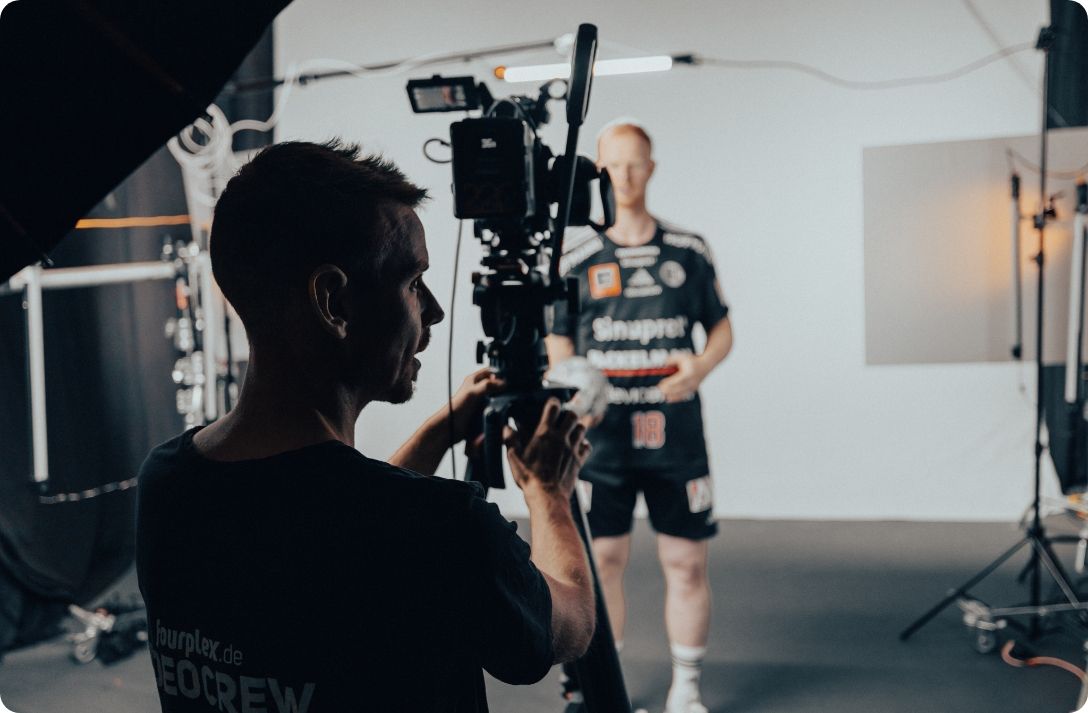 Kameramann der fourplex-Videocrew filmt im Studio einen Spieler des HC Erlangen im schwarzen Trikot mit der Nummer 18