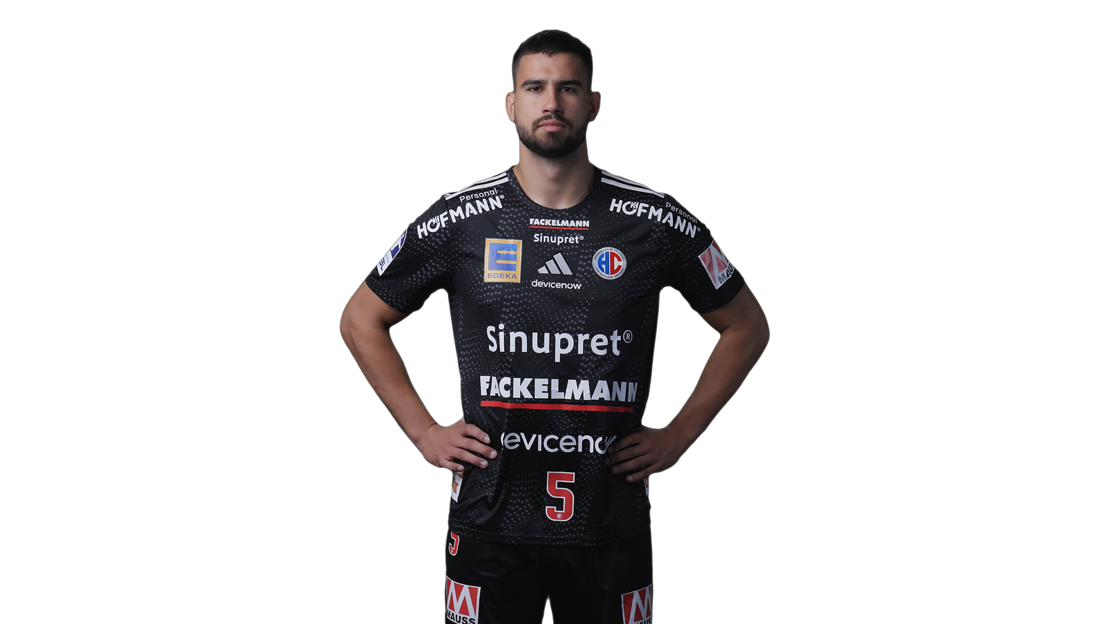 Miloš Kos vom HC Erlangen im schwarzen Trikot mit der Nummer 5, freigestellt mit in die Hüften gestemmten Händen