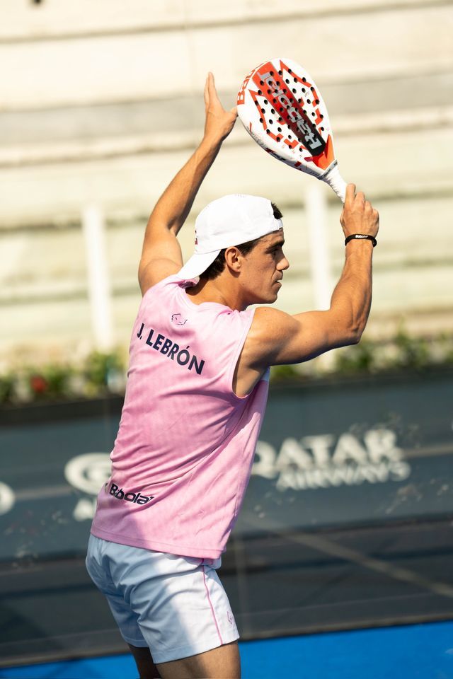 Padelspieler im rosa Babolat-Shirt mit Aufschrift „J. Lebrón“ holt mit dem Schläger über dem Kopf zum Schlag aus