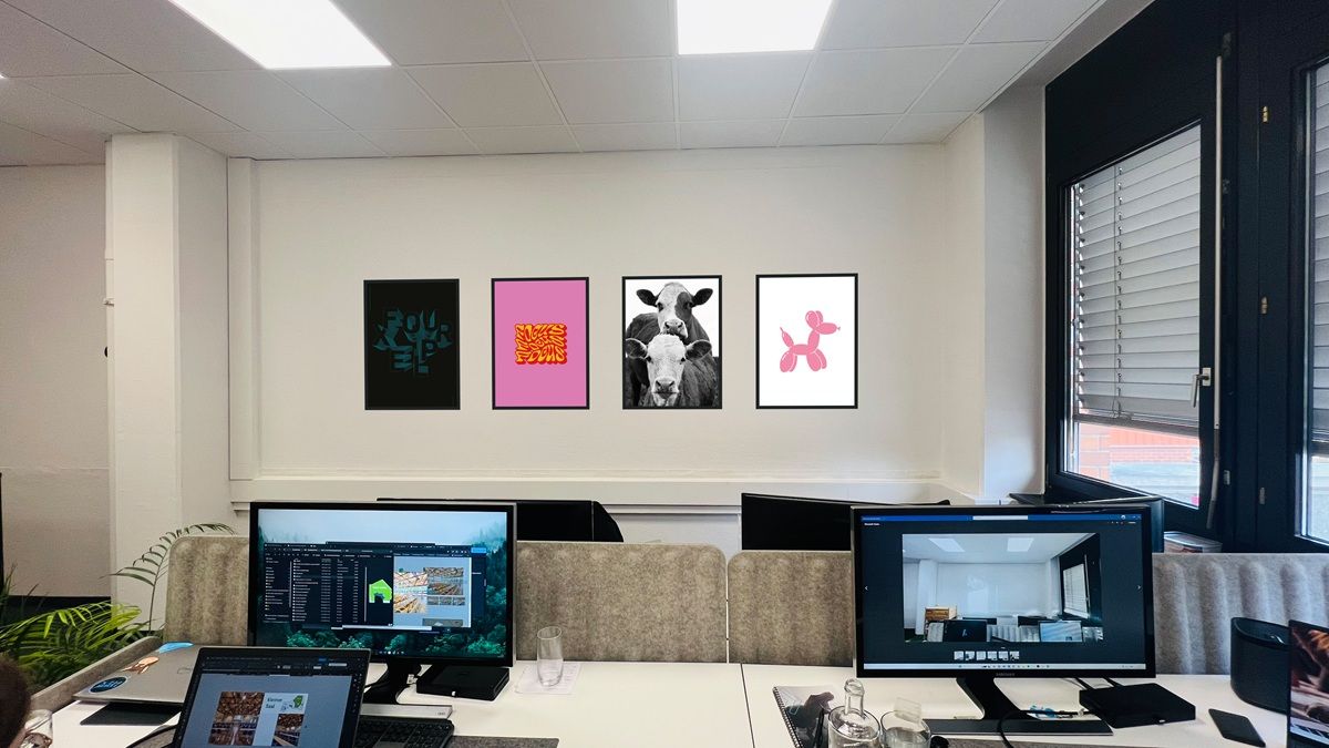 Arbeitsplätze im fourplex Büro in der Nürnberger Südstadt mit gerahmten Postern an der Wand