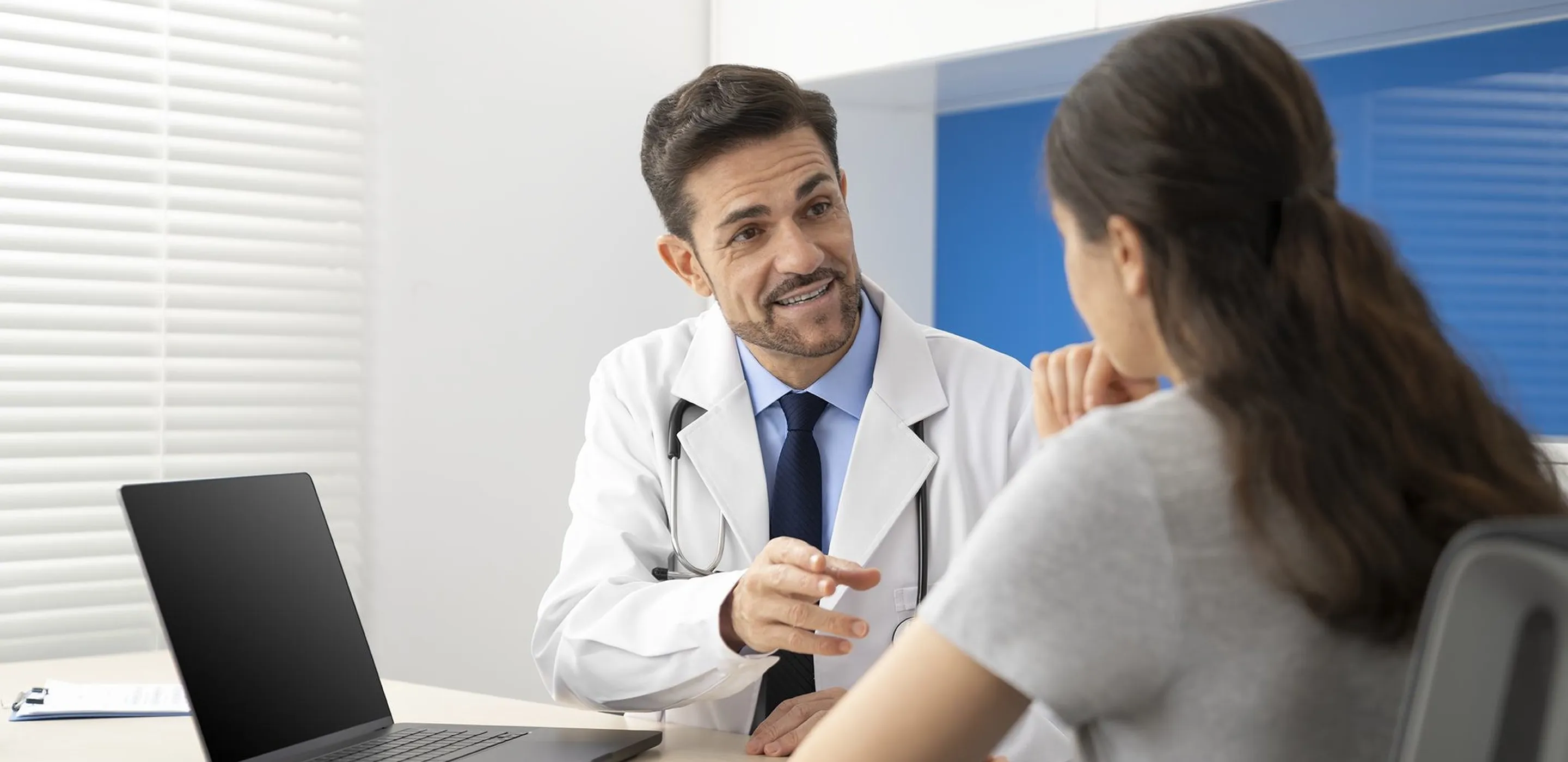 Clinician talking with a colleague across a desk