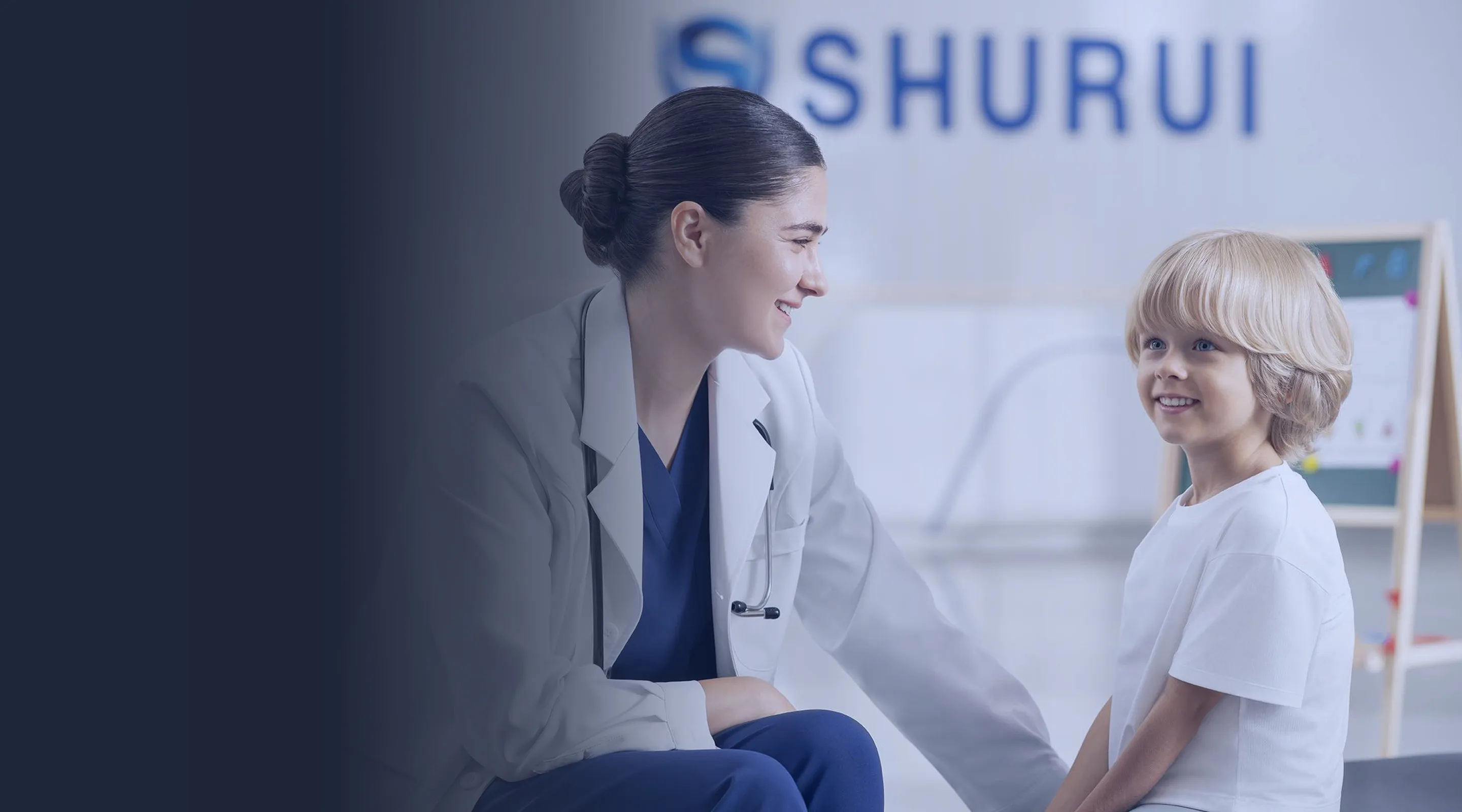 Clinician smiling at a young patient in a consultation room