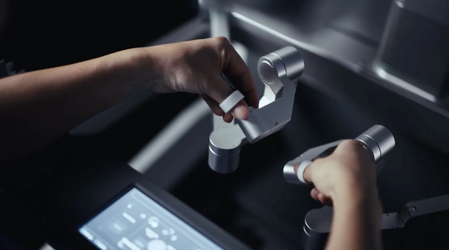 Surgeon hands on the console controls beside the touchscreen