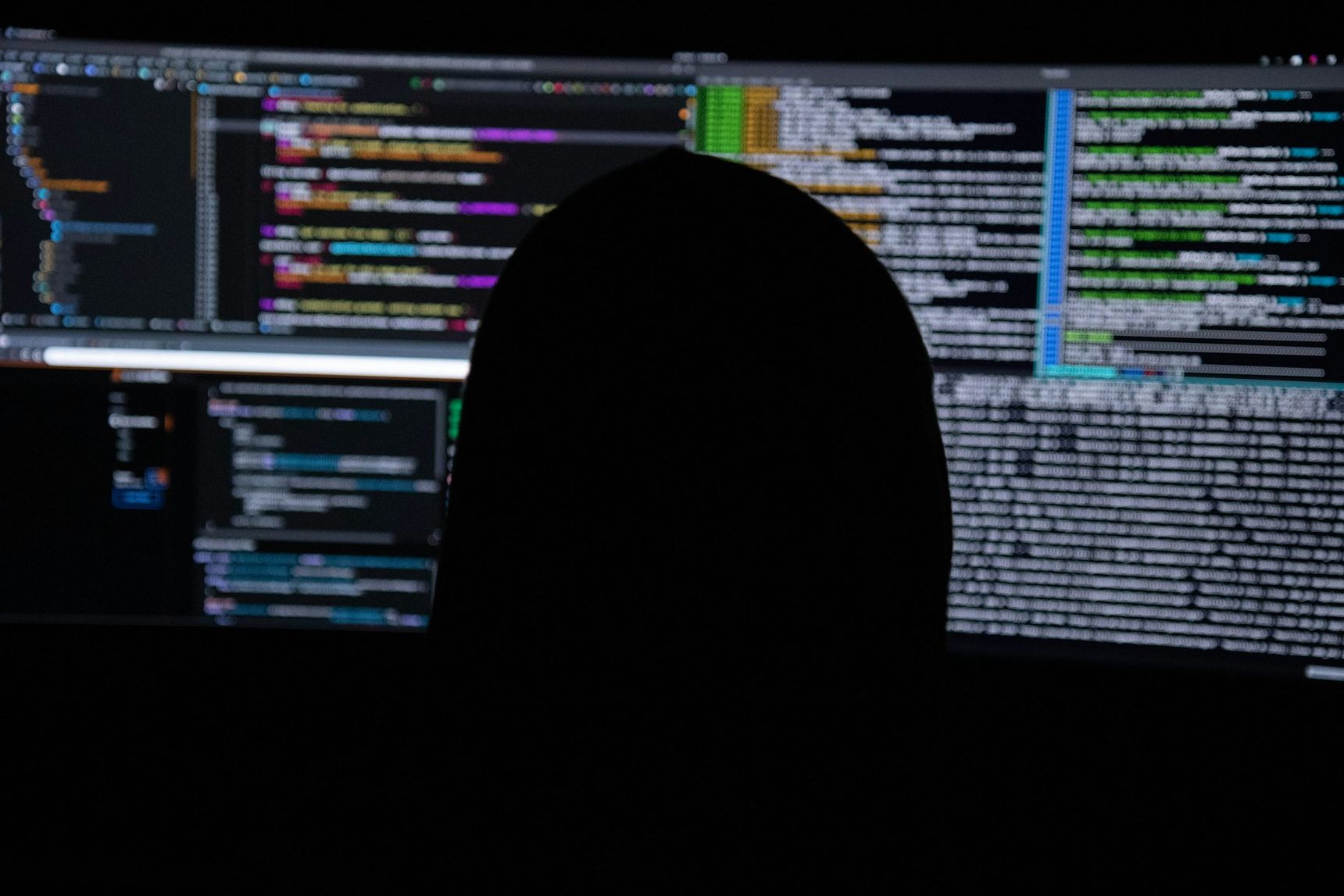 Code op een scherm in het donker, verwijzend naar hacking en AI-beveiliging