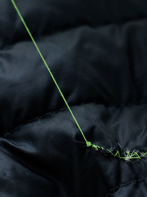 A picture of a down jacket being fixed with stitching.