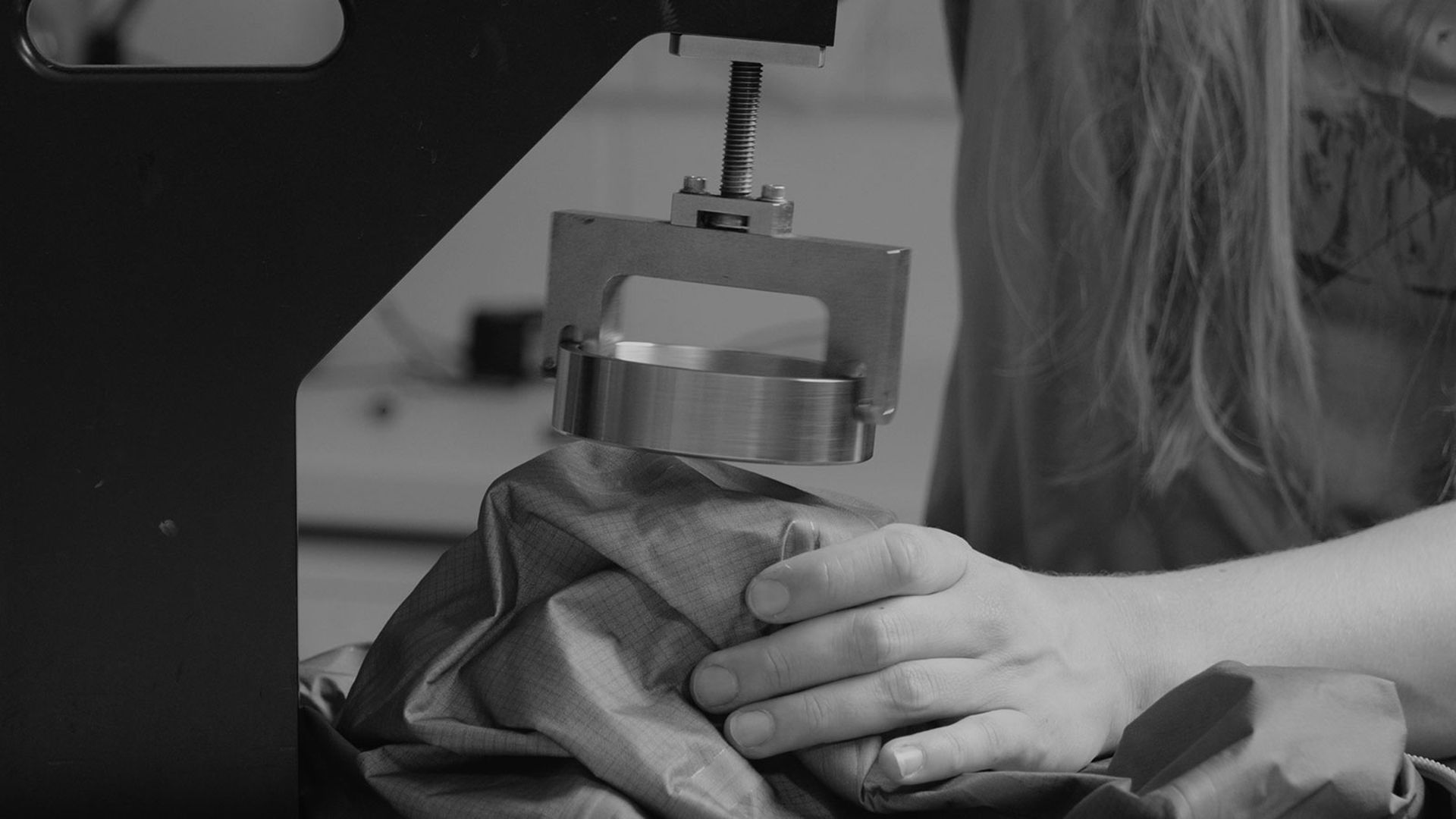 A black and white image of a device that tests abrasion resistance on fabric.