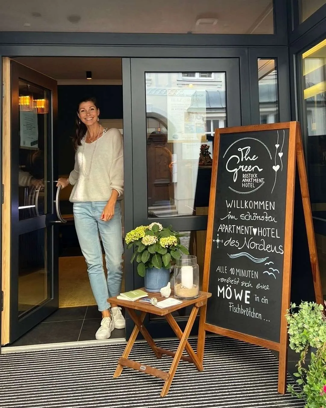 Schneebedeckte Straßen mit Weihnachtsmarktständen in Rostock, die festlich beleuchtet sind und eine warme, einladende Atmosphäre bieten – www.the-green.de.