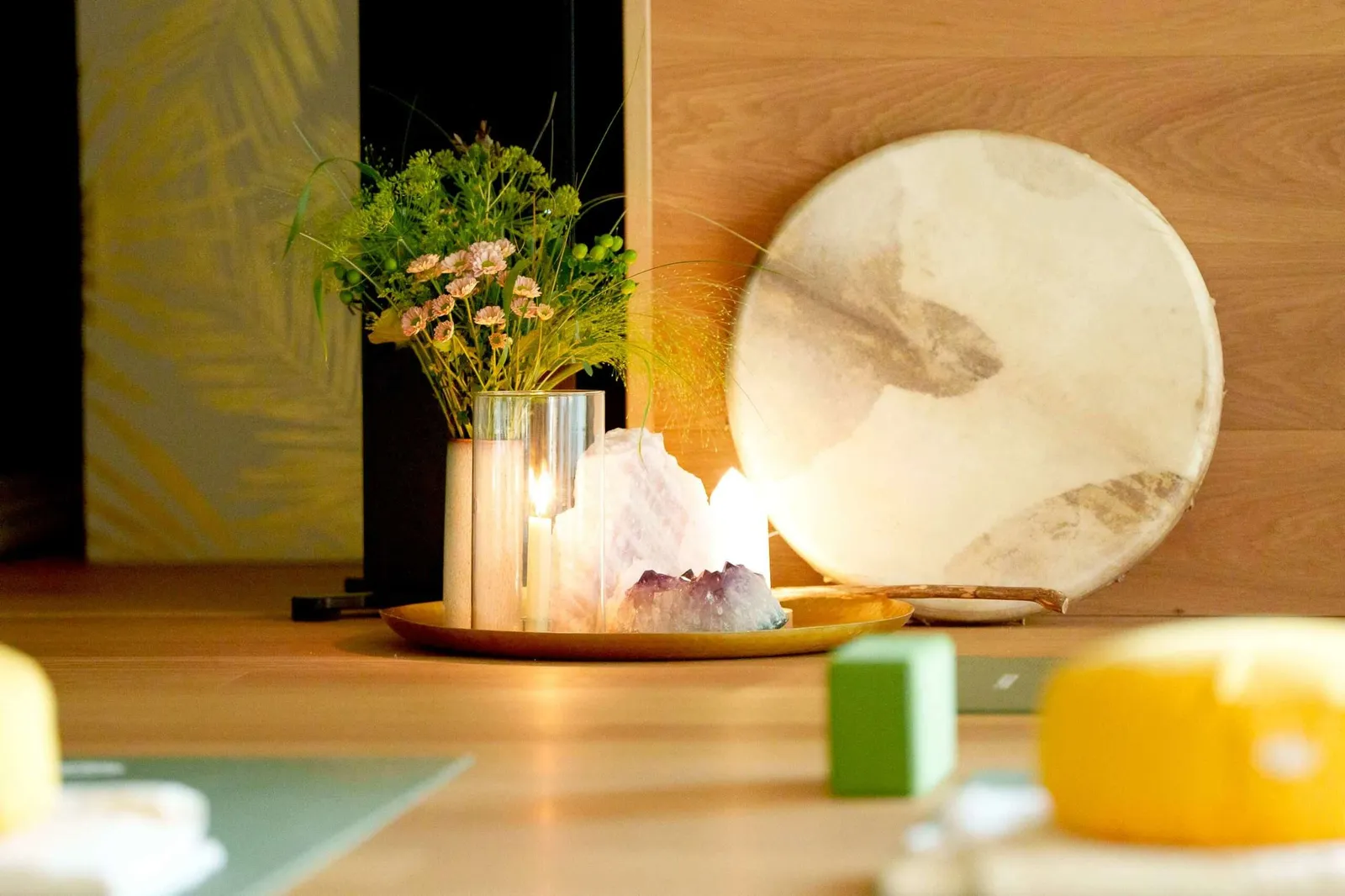 Yoga-Detailaufnahme mit Kerze, Kristallen und Blumen im The Green Retreat Rostock