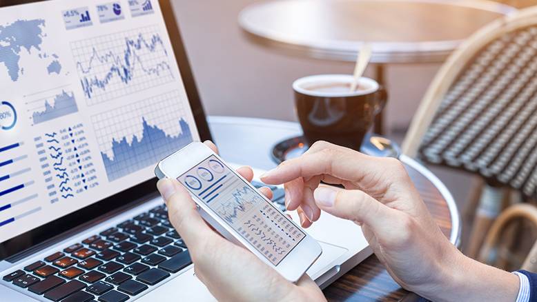 managing finances on laptop and smartphone