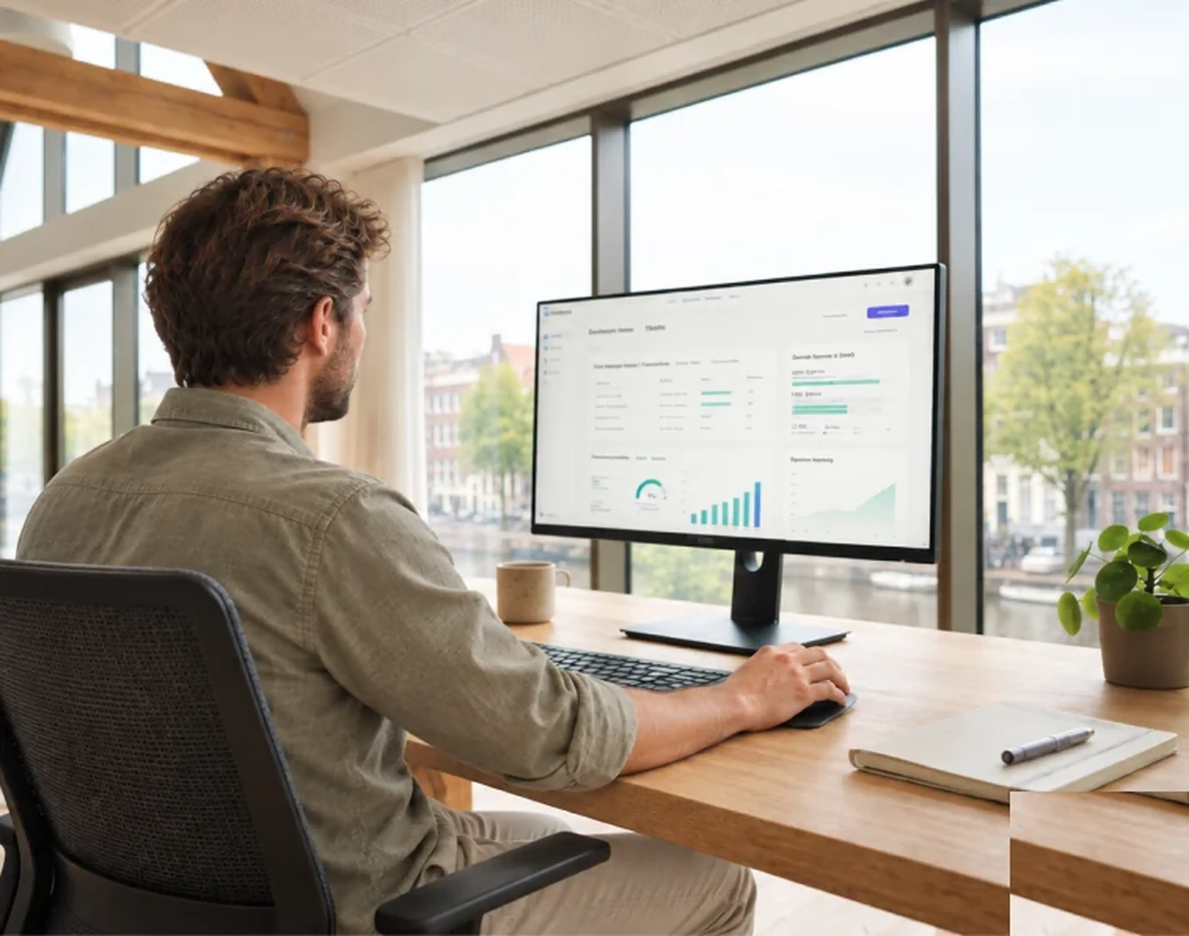 Medewerker aan een bureau met een dashboard op het scherm