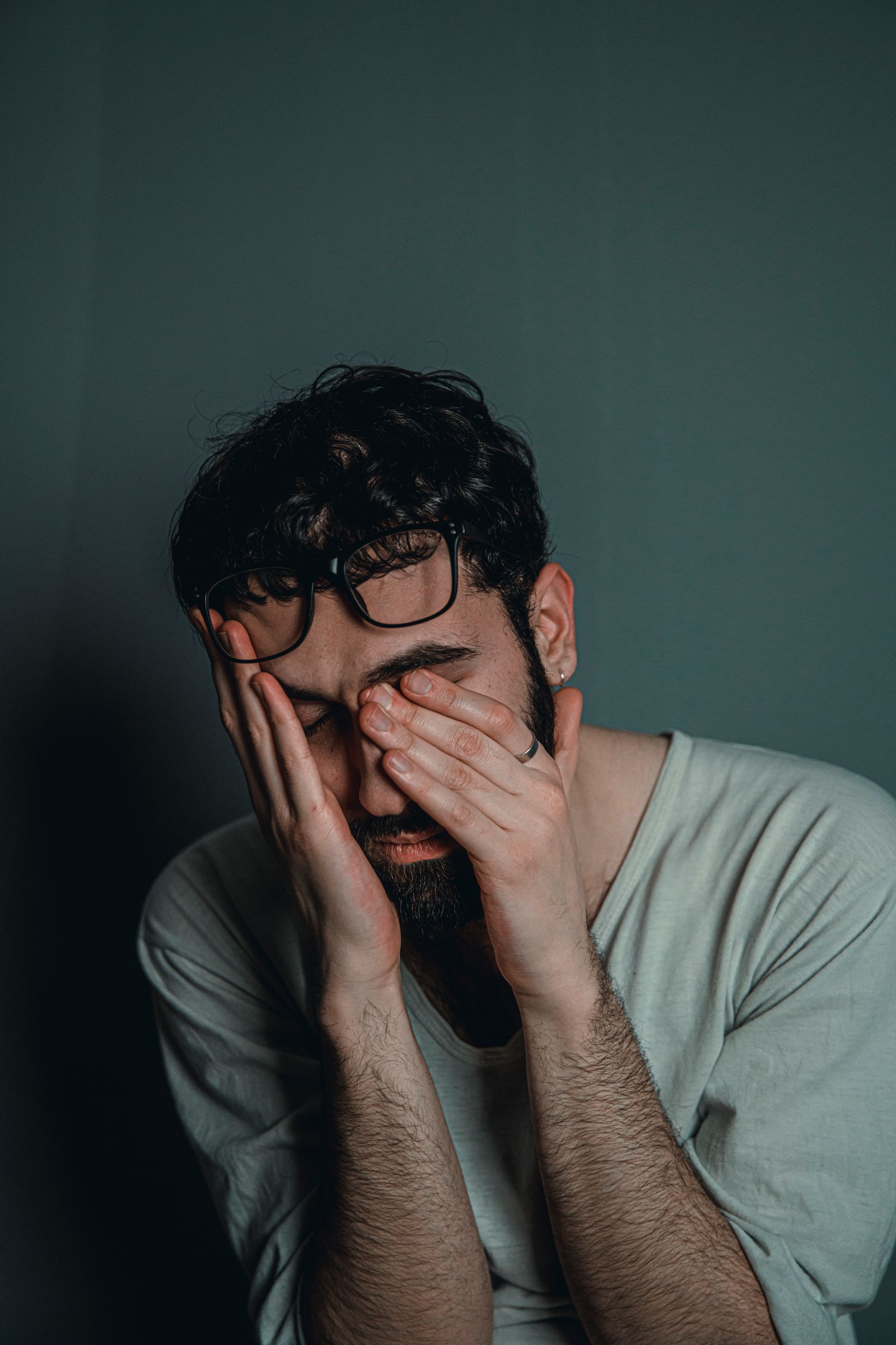 Man covering his face with his hands while experiencing stress and exhaustion