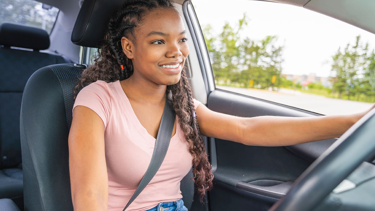 Young woman with her seat buckled driving a car