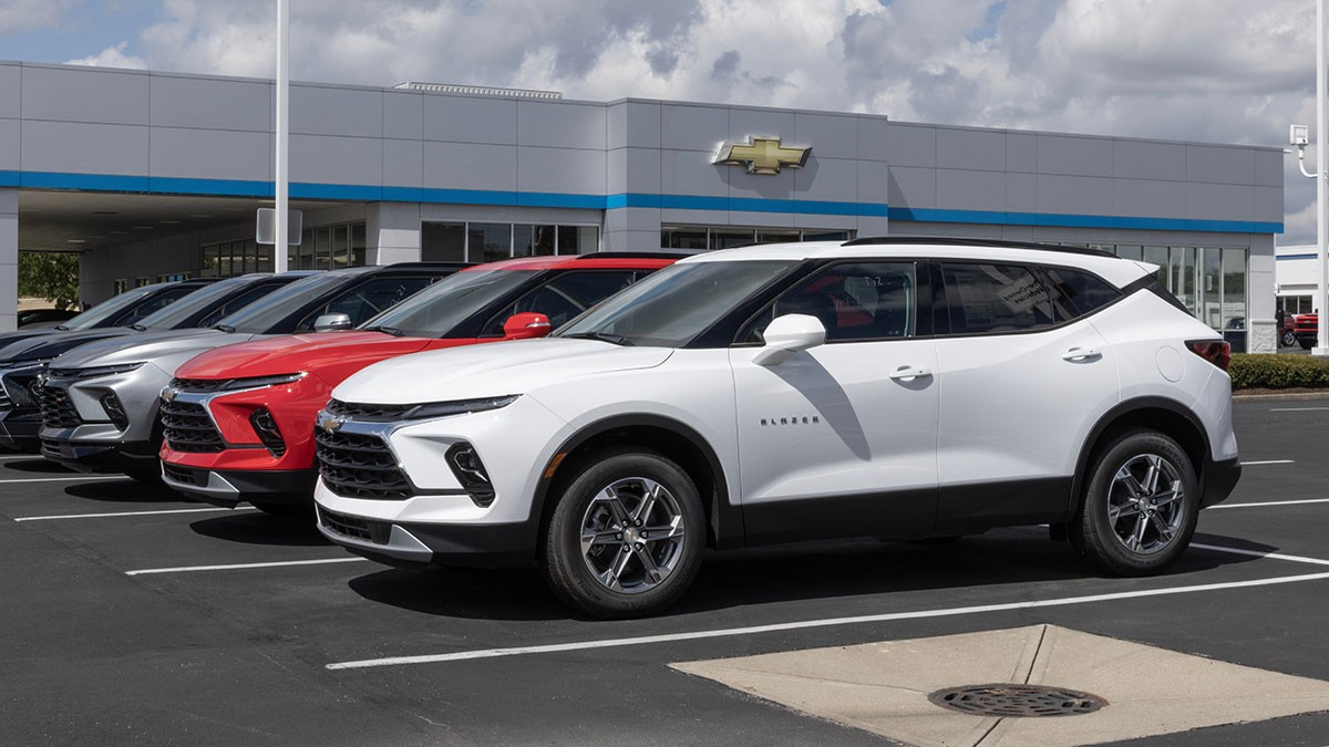 Row of Chevrolet SUVs in various colors parked outside a dealership on a sunny day.