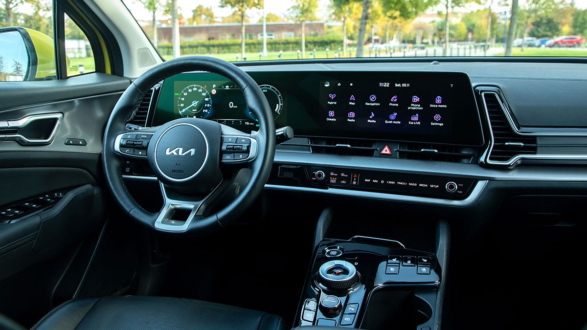Interior view of a modern car showing a sleek dashboard with digital displays, a steering wheel with controls, and a central console.