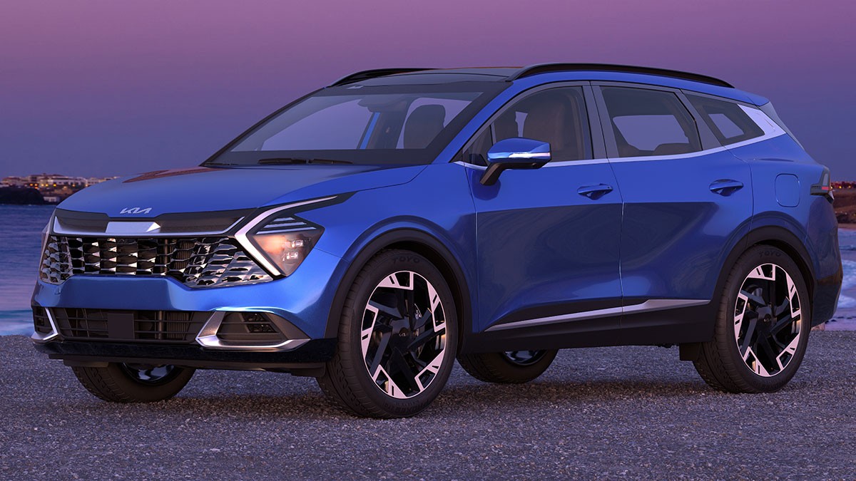 Blue SUV parked on a gravel surface by the sea at sunset, featuring a modern design with sleek headlights and a prominent grille.