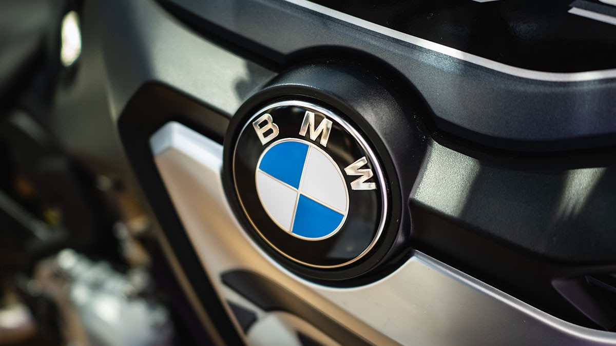 Close-up of a BMW logo on a vehicle, featuring the iconic blue and white emblem set against a sleek, dark surface.
