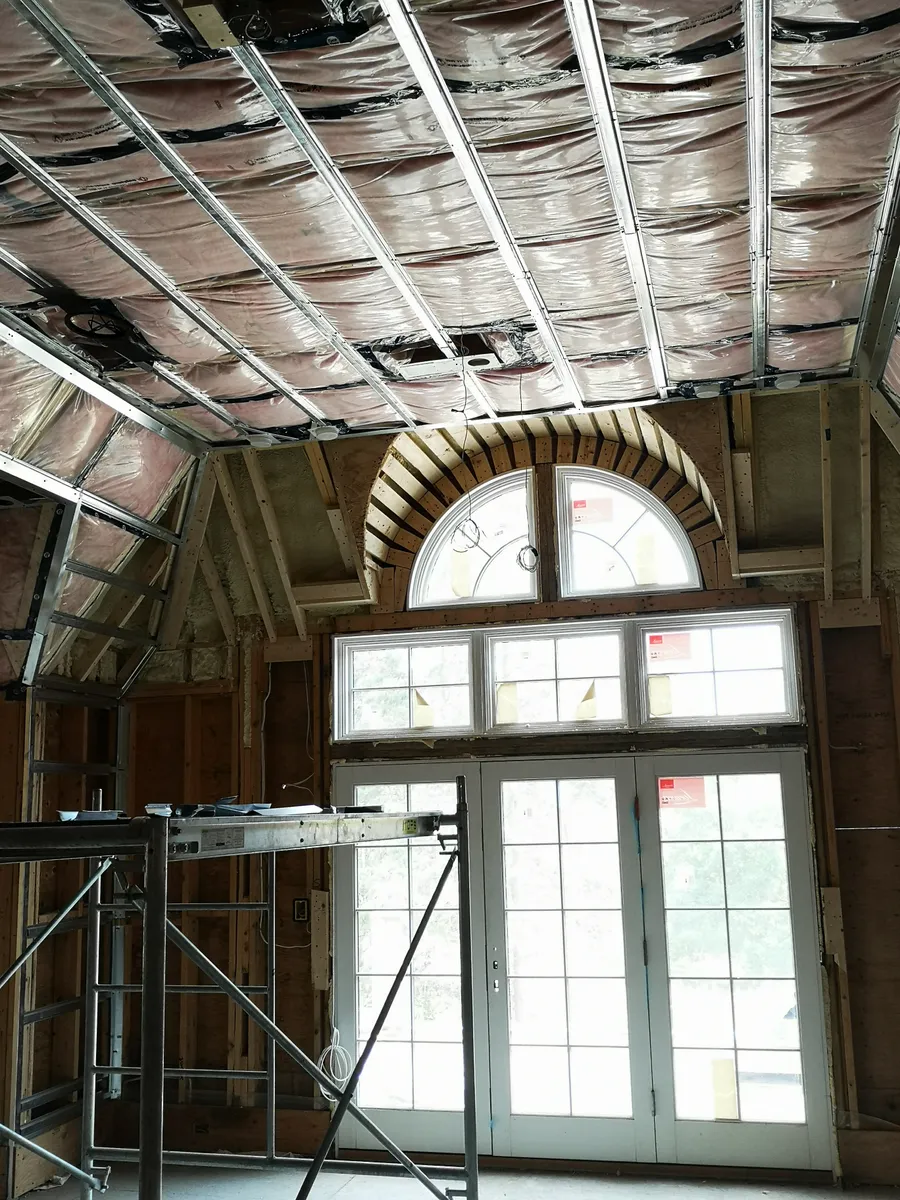Residential interior framing around a large arched window opening