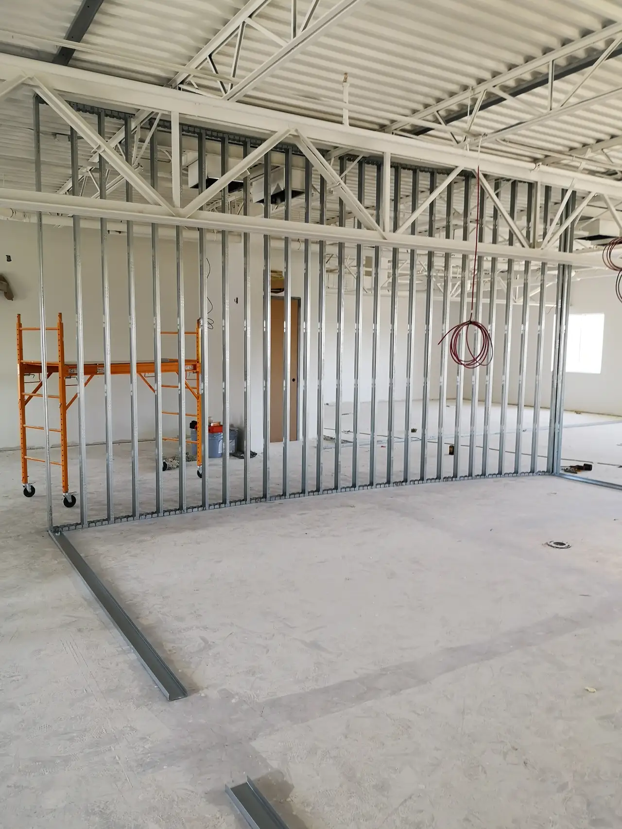 Light-gauge steel stud partition framing in an unfinished interior