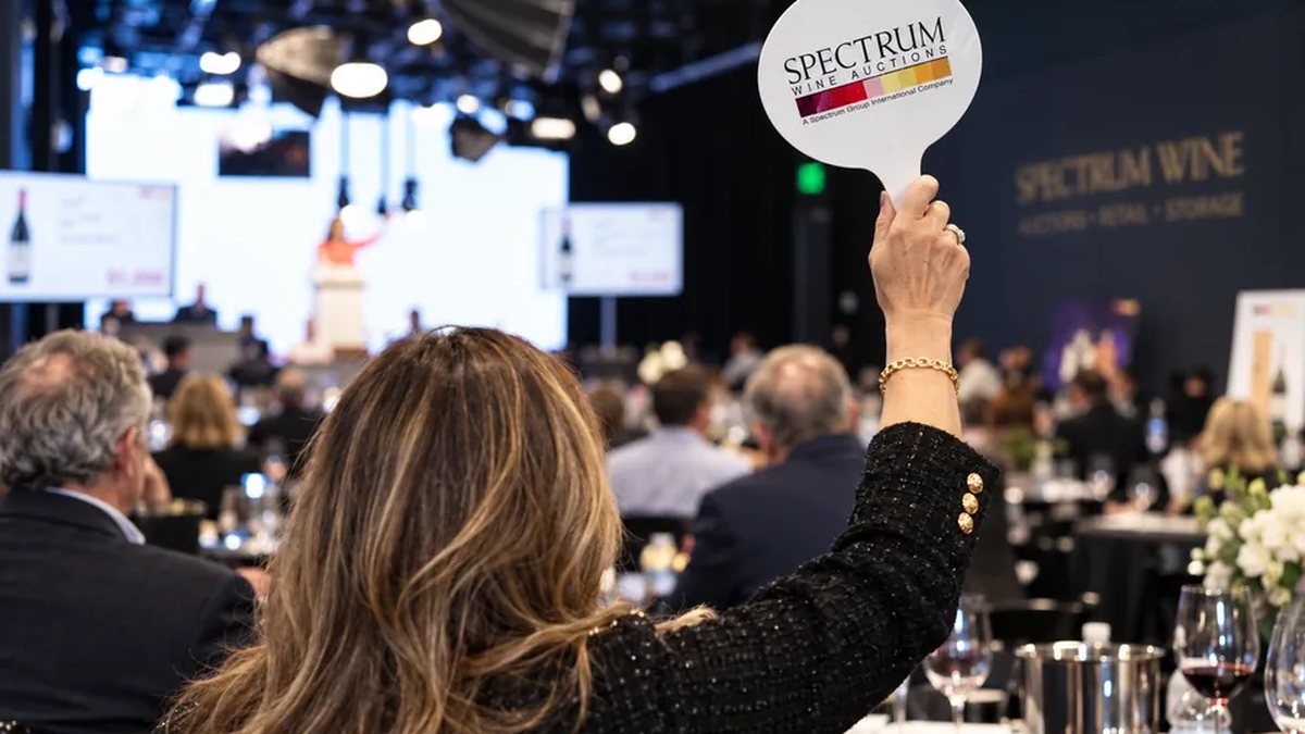 A bidder raises a Spectrum Wine paddle at a live auction