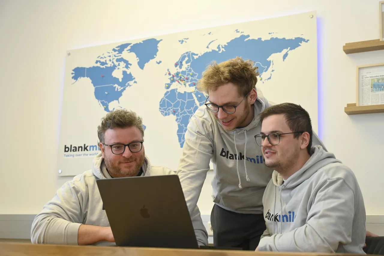 The blankmile team working together at a laptop.