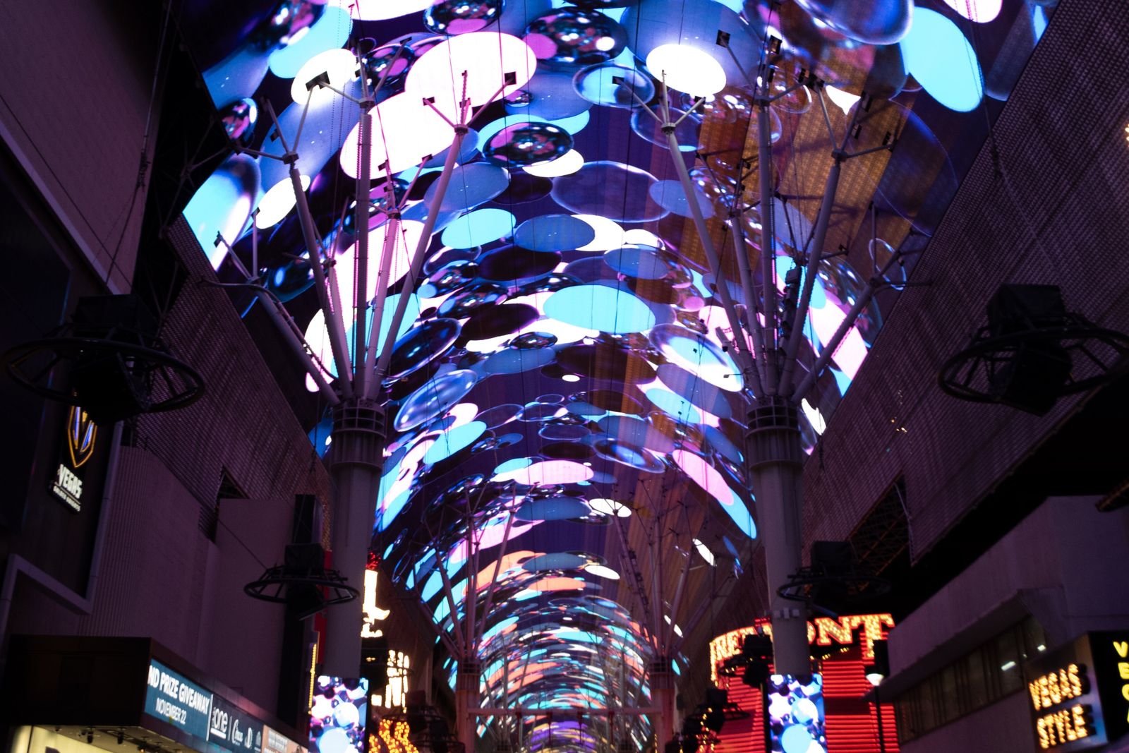 The Fremont Street Experience canopy lit with glowing blue and pink bubble graphics above the pedestrian street