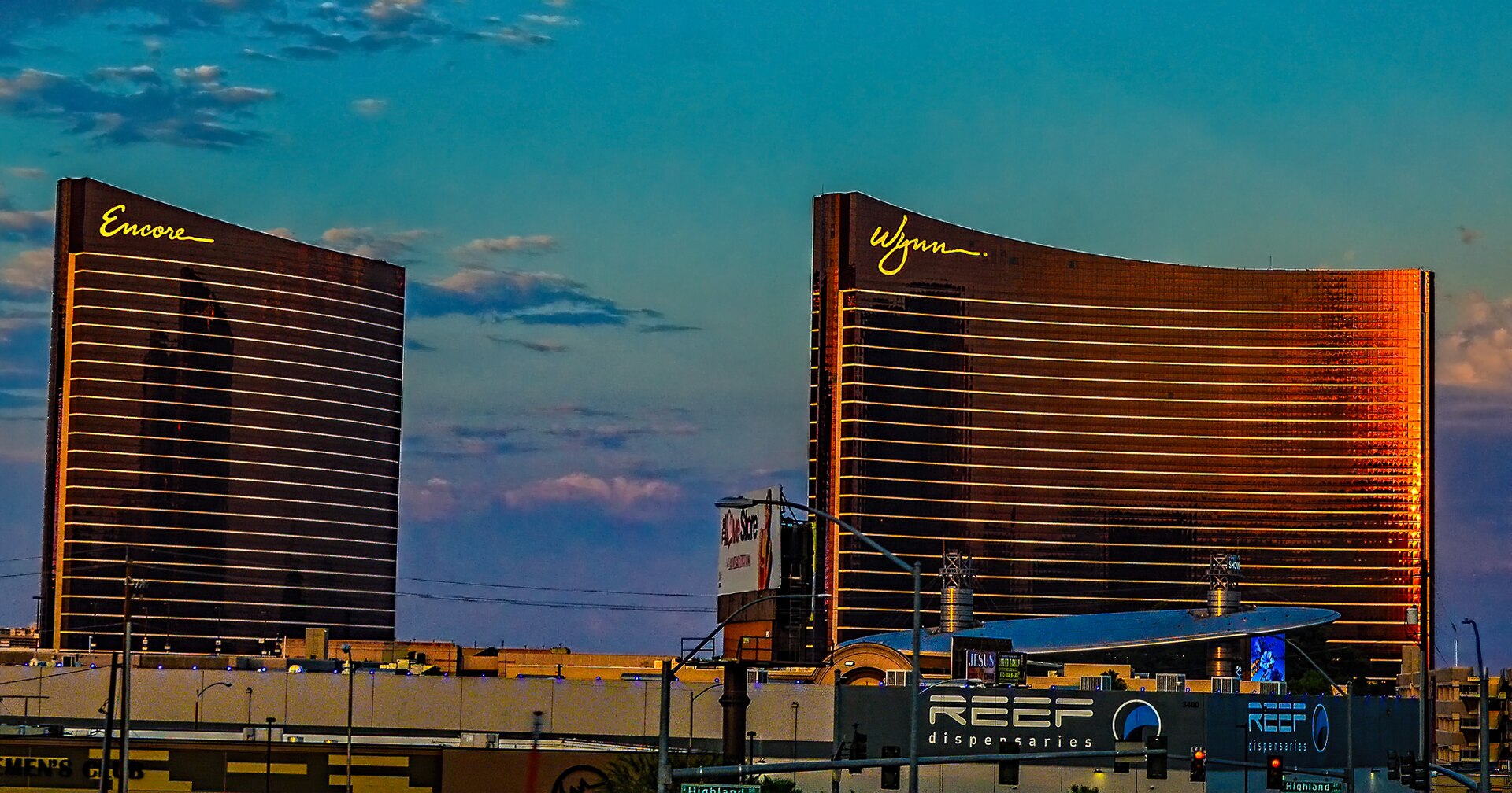 The curved bronze towers of Encore and Wynn Las Vegas glowing at sunset on the North Strip