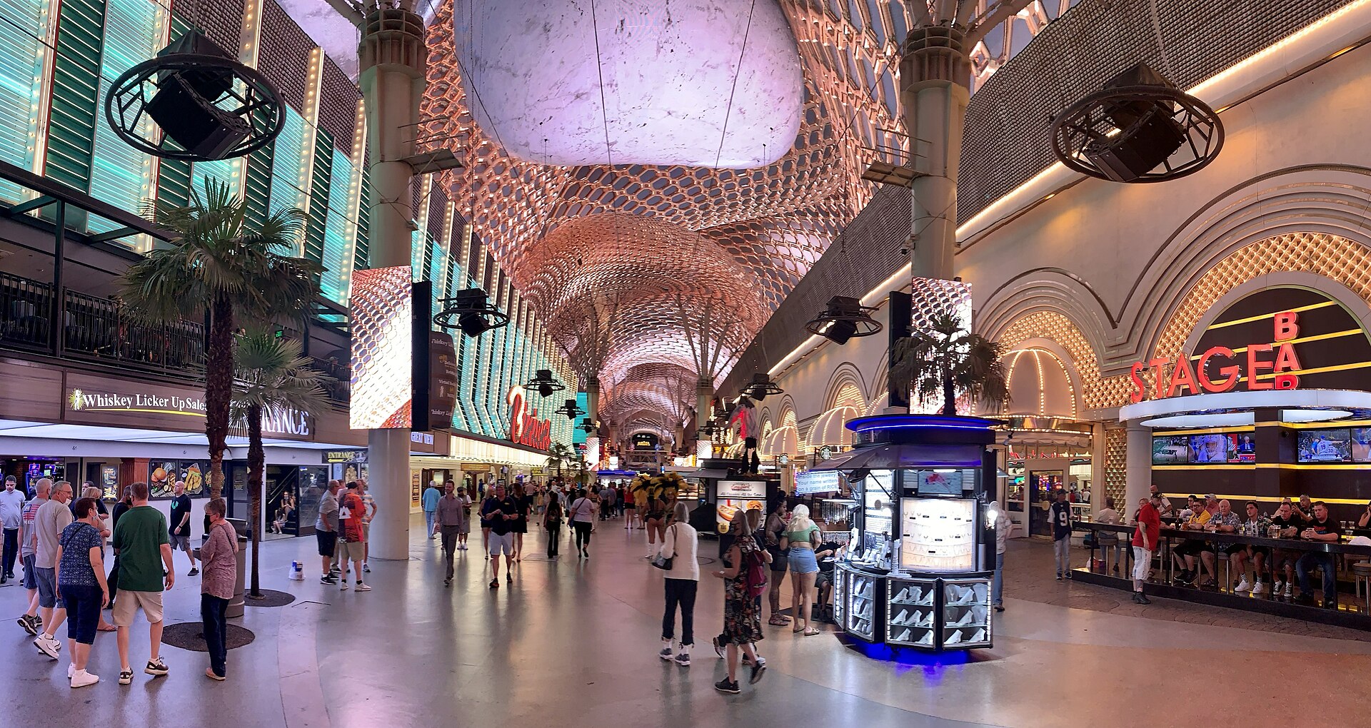 Daytime view down the Fremont Street Experience pedestrian mall under the curved canopy with SlotZilla signs