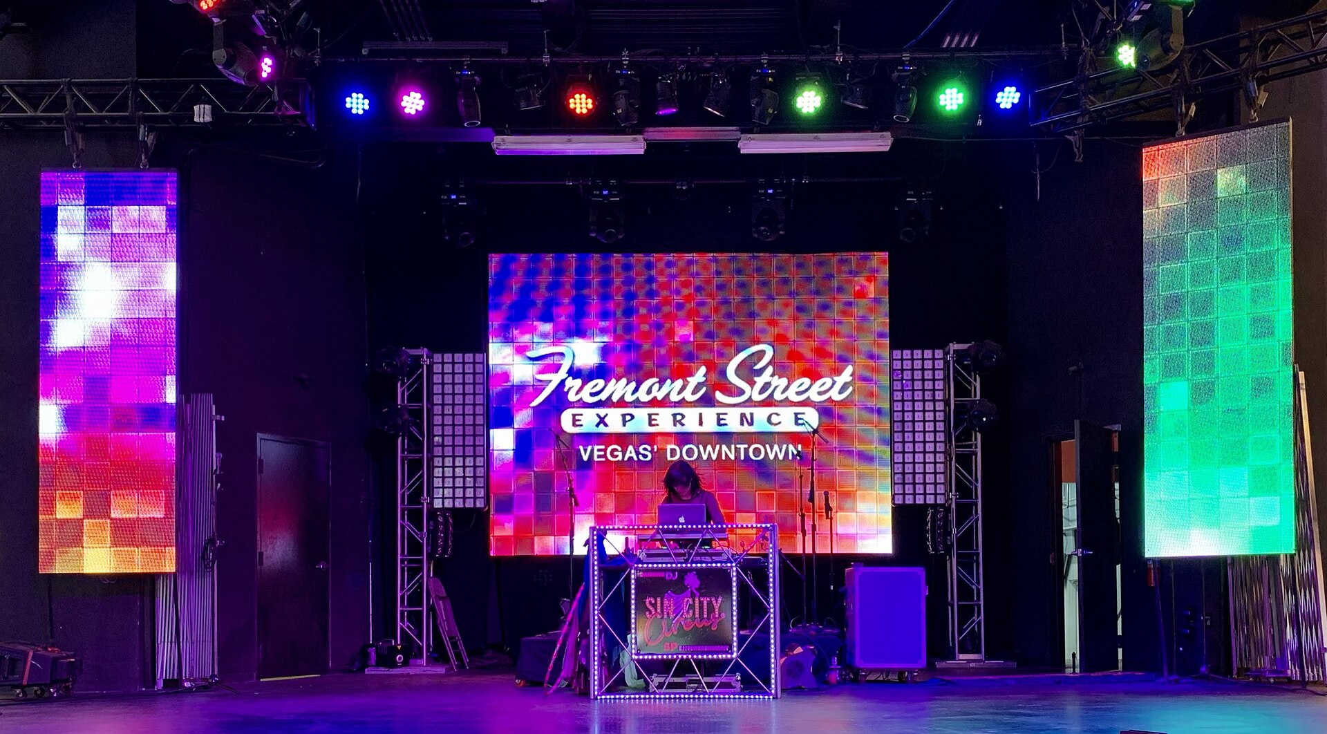 An outdoor Fremont Street Experience music stage lit with colorful LED screens and lights