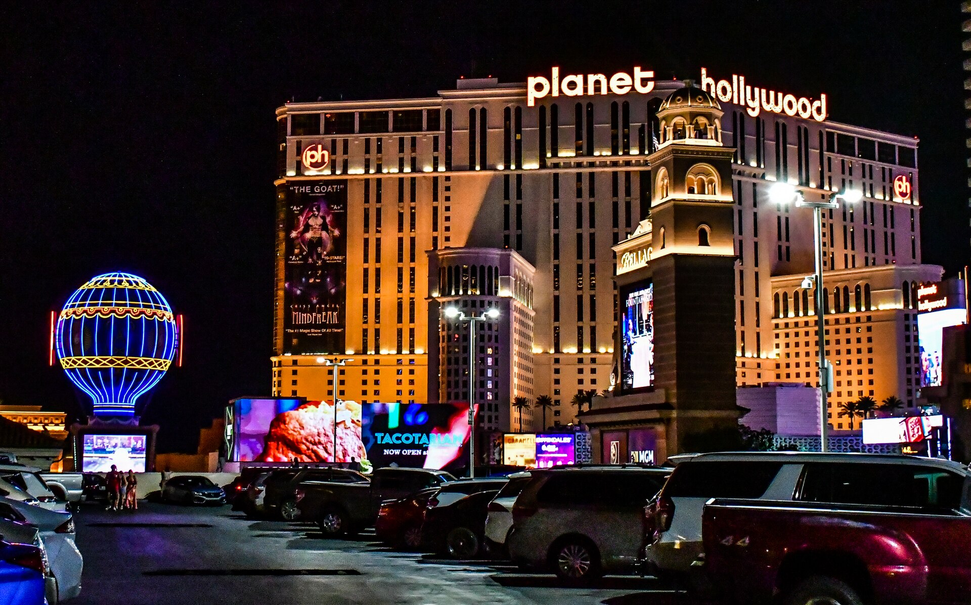 Planet Hollywood Las Vegas hotel tower lit up at night with the Paris balloon sign on the left