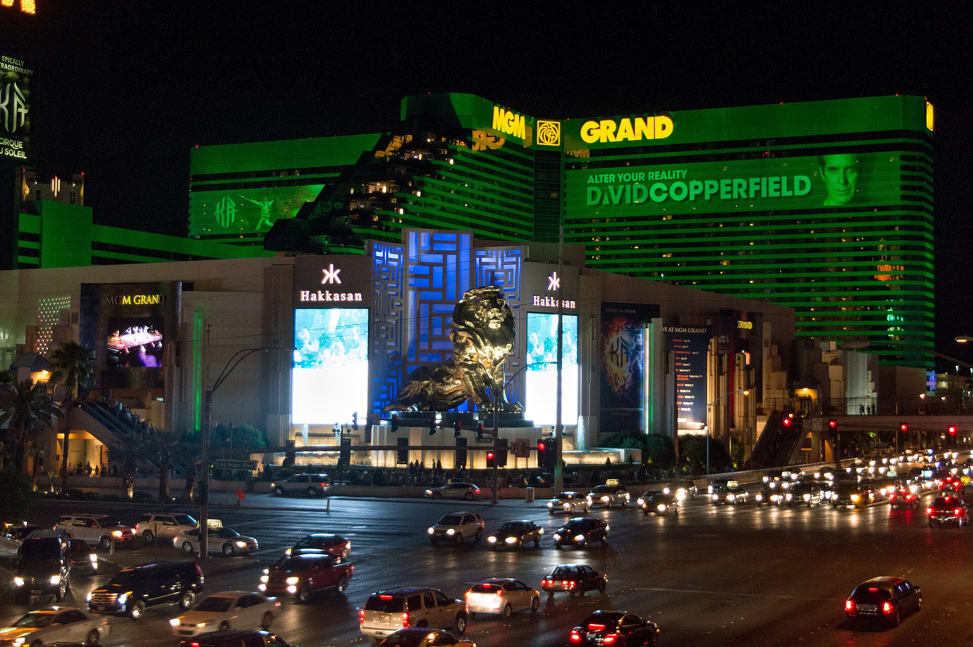 MGM Grand hotel towers lit up green at night, seen from the southwest