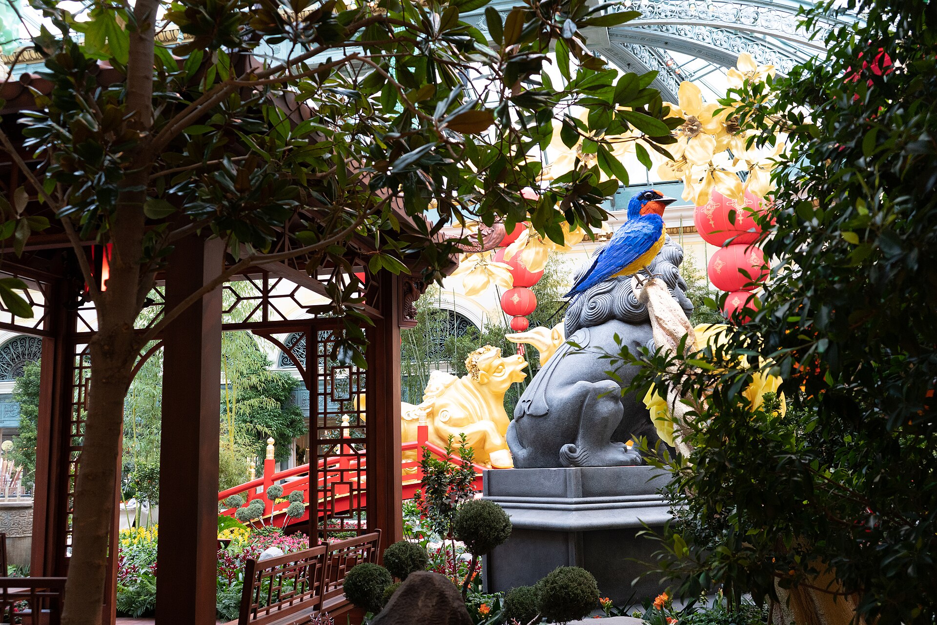 Bellagio Conservatory with a wooden pavilion, trees, red lanterns and a large bird sculpture