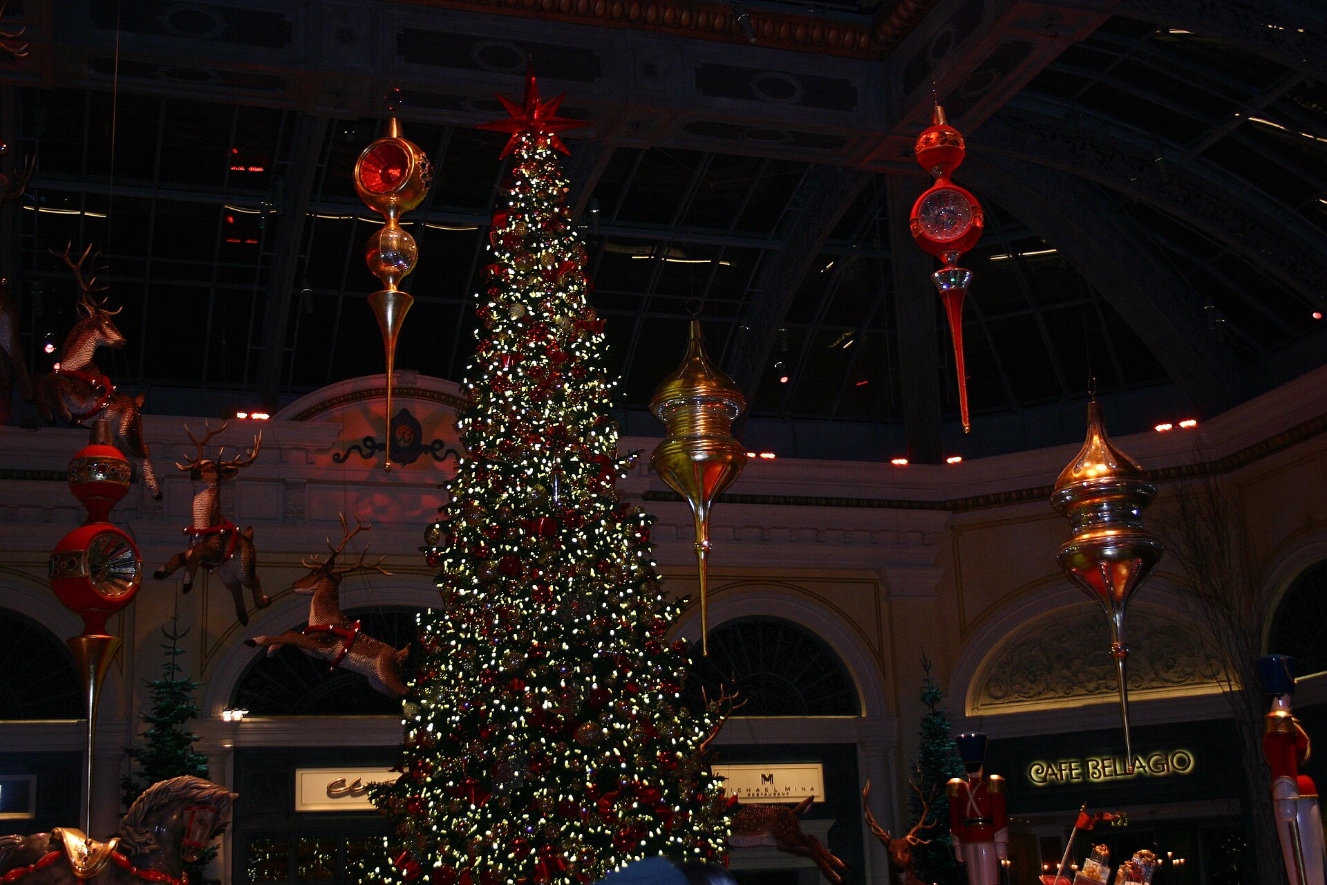 Bellagio Conservatory decorated for the holidays with a tall lit Christmas tree, giant ornaments and reindeer