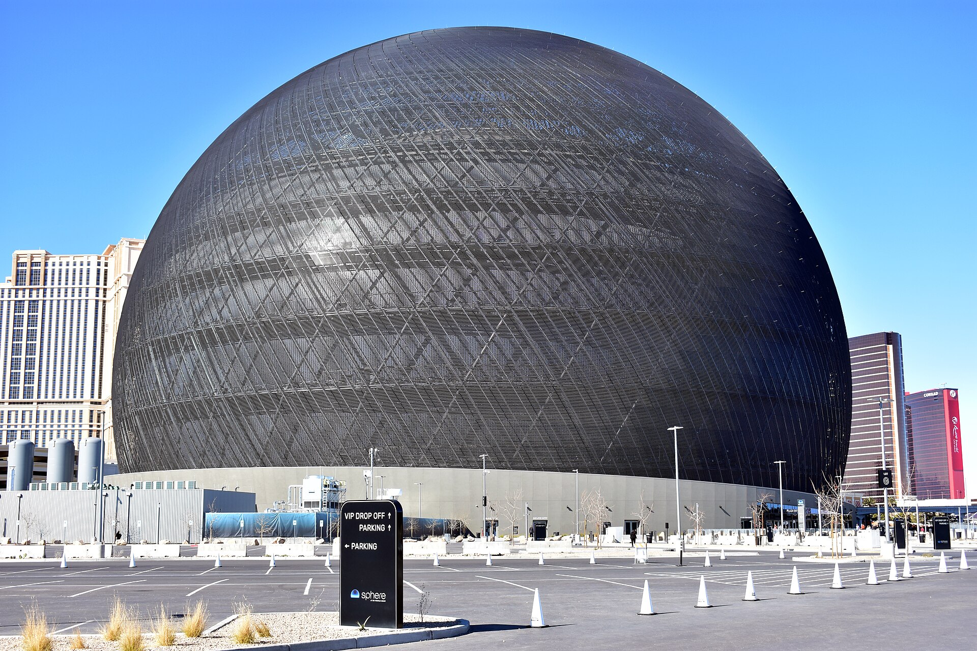 Sphere in Las Vegas in daylight with its dark unlit LED lattice and a parking lot in front